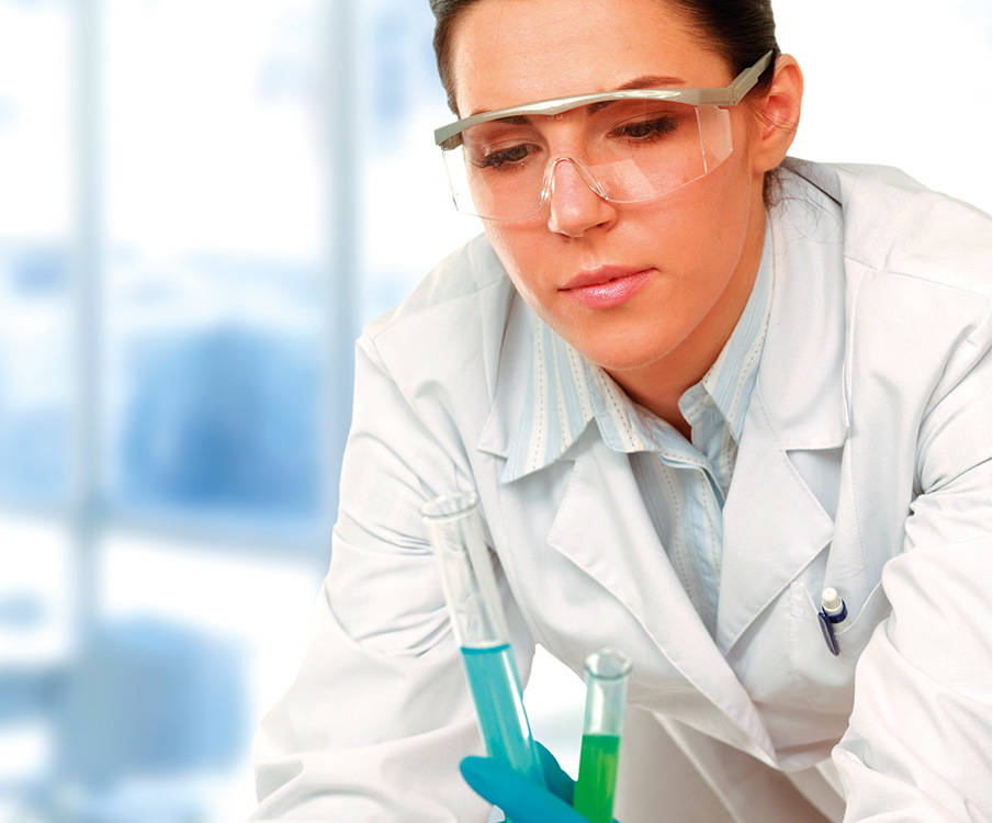 Nainen katsoo koeputkia laboratoriossa